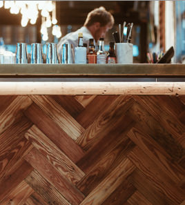 Wooden bar with glass cups and silverware on top